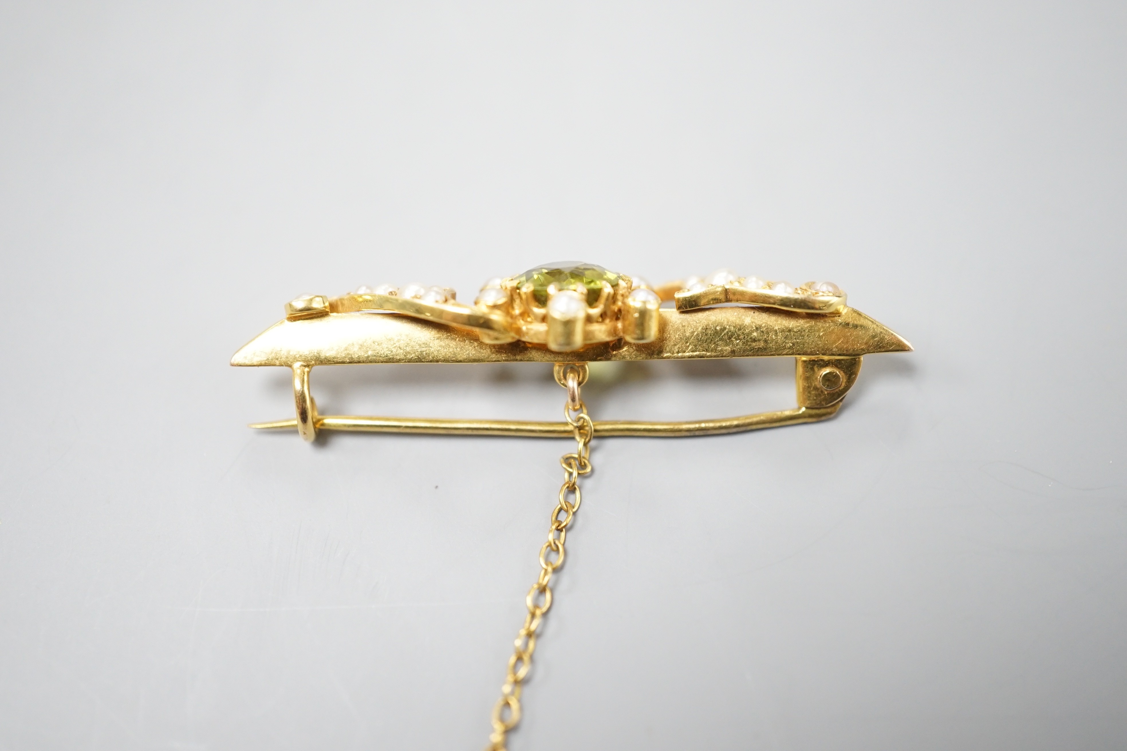 An Edwardian 15ct, peridot and seed pearl set bar brooch, 43mm, gross weight 4.2 grams.